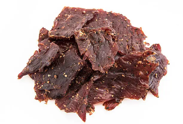 Heap of Peppered Beef Jerky on white background