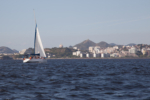 Rio de Janeiro, Brazil – September 09, 2023: sailboat sailing towards Niteroi in Guanabara Bay. In the background of the image you can see Icarai Beach.