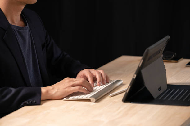 istock Close up of man using digital tablet, finger touching on screen and working on laptop computer, browsing the internet, networking at home office, online working, freelancer at work 1685411199