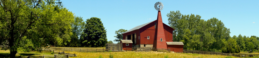 Beautiful Midwestern Farm scene.Red barn takes center stage with restored windmill.Rail fence can be seen winding the landscape.Taken on a beautiful summer day.
