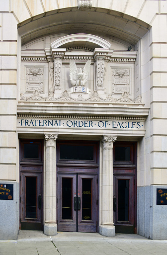 Seattle, King County, Washington state, United States: Fraternal Order of Eagles, entrance with sign and terracotta eagle - Fraternal Order of Eagles (F.O.E.) is a fraternal organization founded 1898, in Seattle, Washington. Originally made up of those engaged in one way or another in the performing arts, the Eagles grew and claimed credit for establishing the Mother's Day holiday in the United States as well as the \