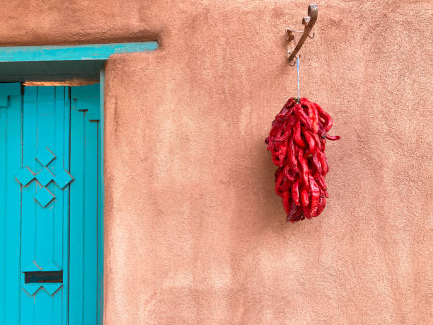 santa fe, nm: red chili ristra, adobe wall, turquoise door - ristra fotografías e imágenes de stock