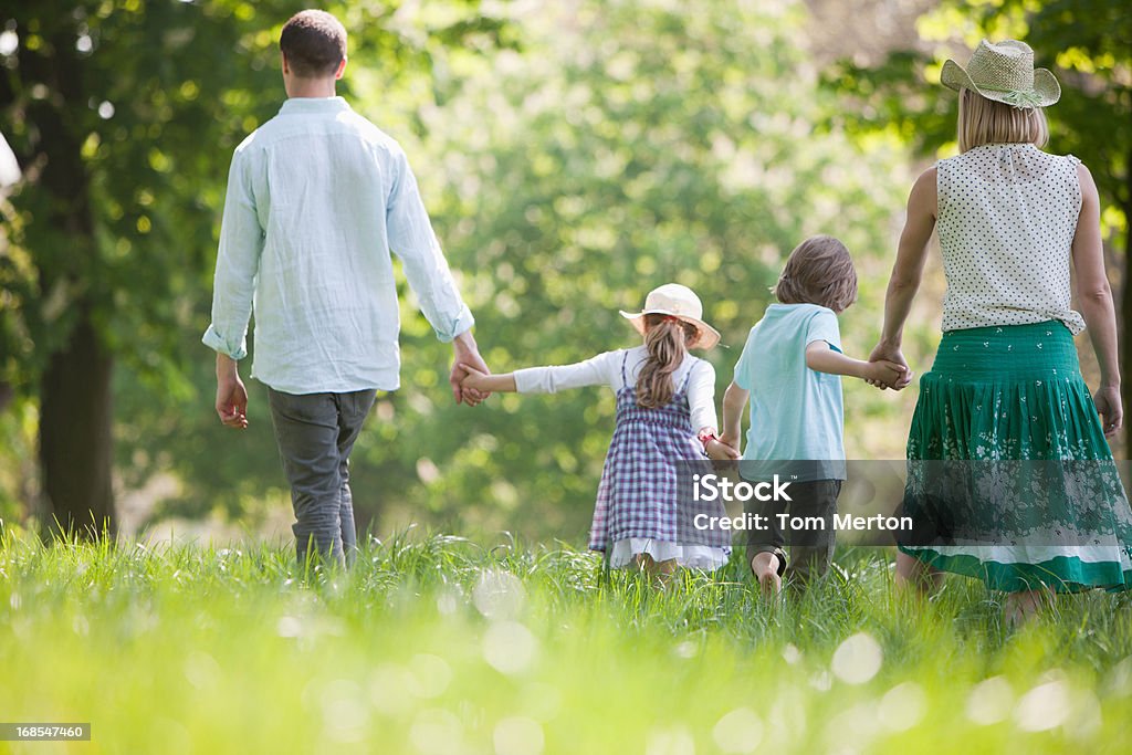 Familie gehen in Feld mit Blumen - Lizenzfrei Beide Elternteile Stock-Foto