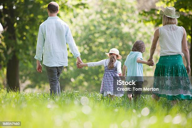Familie Gehen In Feld Mit Blumen Stockfoto und mehr Bilder von Beide Elternteile - Beide Elternteile, Gehen, 25-29 Jahre