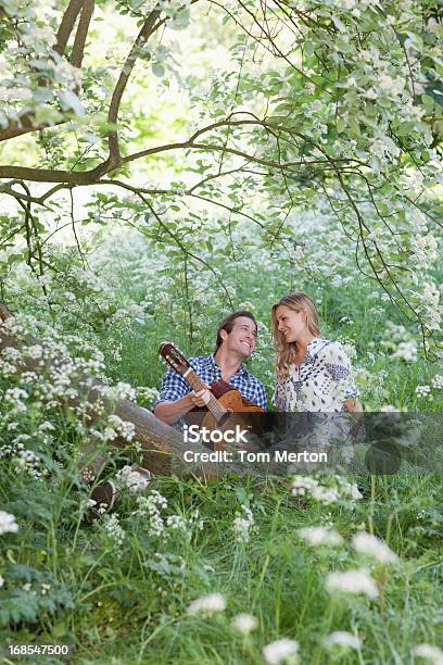 Uomo Che Suona La Chitarra Per Ragazza Nella Foresta - Fotografie stock e altre immagini di 25-29 anni