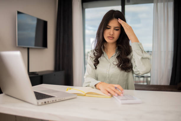 istock Young woman using calculator while going through bills and home finances 1685502619