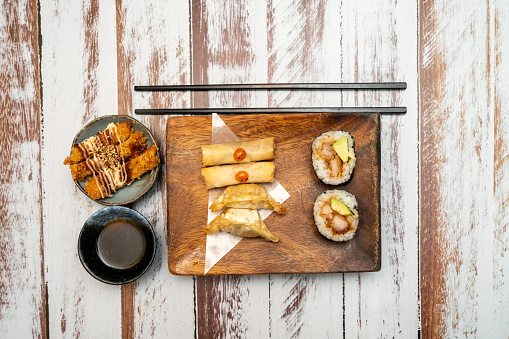 Japanese food mix on rustic board in a restaurant table