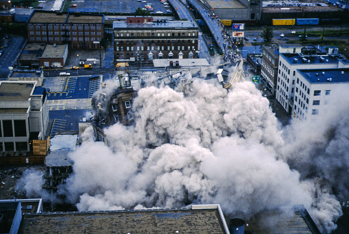 In the controlled demolition industry, building implosion is the strategic placing of explosive material and timing of its detonation so that a structure collapses on itself in a matter of seconds, minimizing the physical damage to its immediate surroundings.