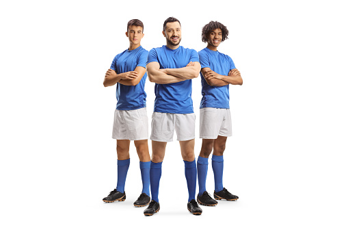 Three football players in blue jerseys posing isolated on white background