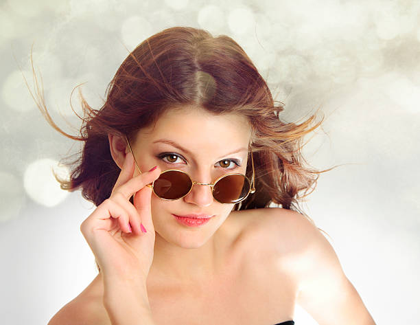 Trendy Young Lady in Sunglasses Looking at the Camera stock photo