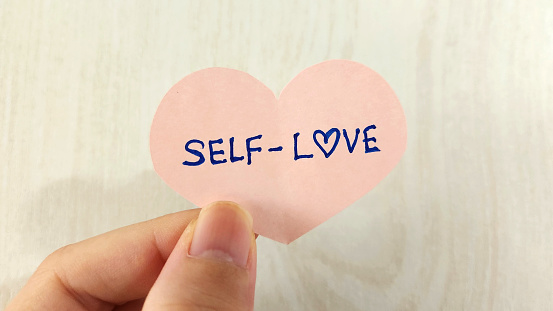 A heart shaped note with the words Self-Love