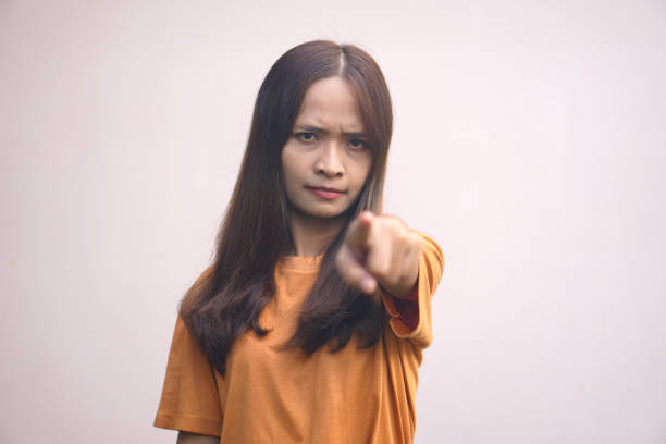 怒ったアジア人女性が指を前に向ける - mad expression image front view horizontal ストックフォトと画像