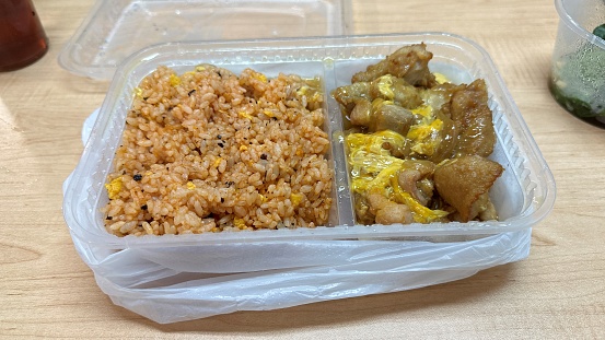 Scrambled egg with pork chop rice. Plastic food box and bag. Cantonese takeaway style