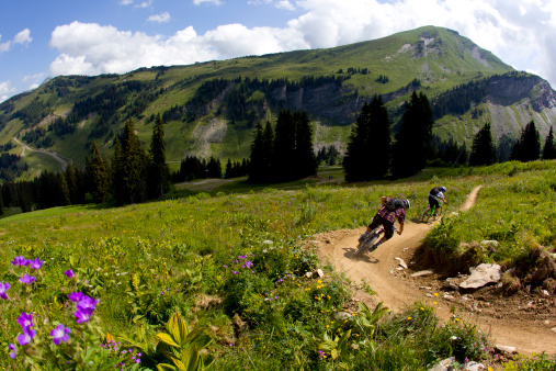 Two downhill mountain bikers ride a trail at the Avoriaz Bike Park in France.