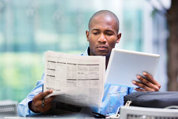 Investor compares quotes from newspaper and tablet