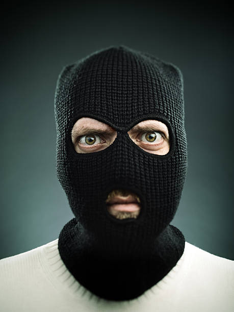 Terrorist portrait Man with a balaclava looking at camera. Black background. burglar stock pictures, royalty-free photos & images