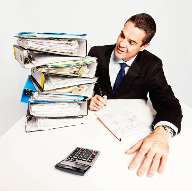 istock Confident businessman eyes enormous stack of work confidently 168582472