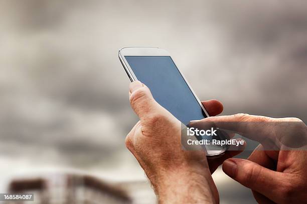 Masculino Mão Torneiras Ecrã Táctil De Telefone Inteligente Na Rua - Fotografias de stock e mais imagens de Bater com os Dedos