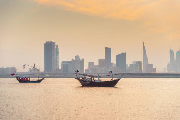 Bahrain Manama Skyline and Dhows at Sunset Skyline of Manama with dhows, the traditional ships, in front of the skyscrapers. Sunset in Manama, Bahrain, Middle East. bahrain stock pictures, royalty-free photos & images