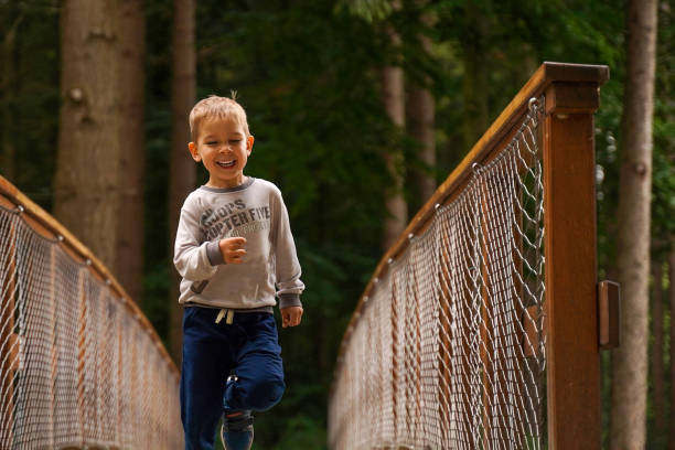 istock A little boy runs merrily through the forest. 1685863859