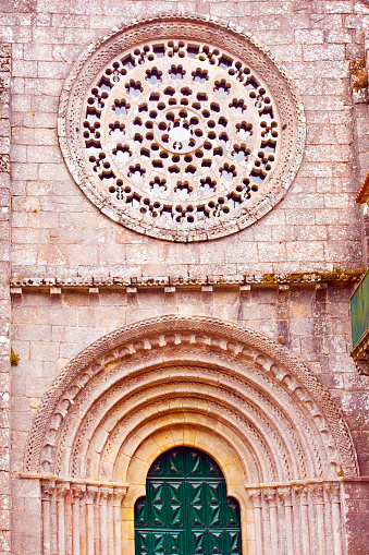 Building exterior close-up view of Armenteira monastery church facade , Meis, Rías Baixas, Pontevedra province, Galicia, Spain, beautiful rose window and doorway arcade.