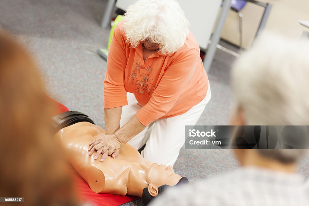 Sênior mulher praticando compressões do peito - Foto de stock de Primeiros socorros royalty-free