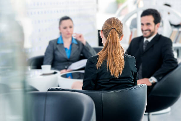 Job Interview Business woman and businessmen sitting by the table and interviewing young woman sitting on the other side of the table,  blurred background mediation photos stock pictures, royalty-free photos & images