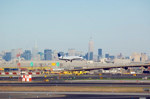 Airplane landing at Newark Airport, New Jersey, USA, with the skyline of lower Manhattan in the background.