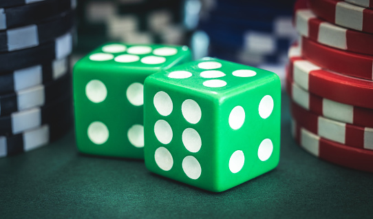 many gambling dice on green shiny casino table