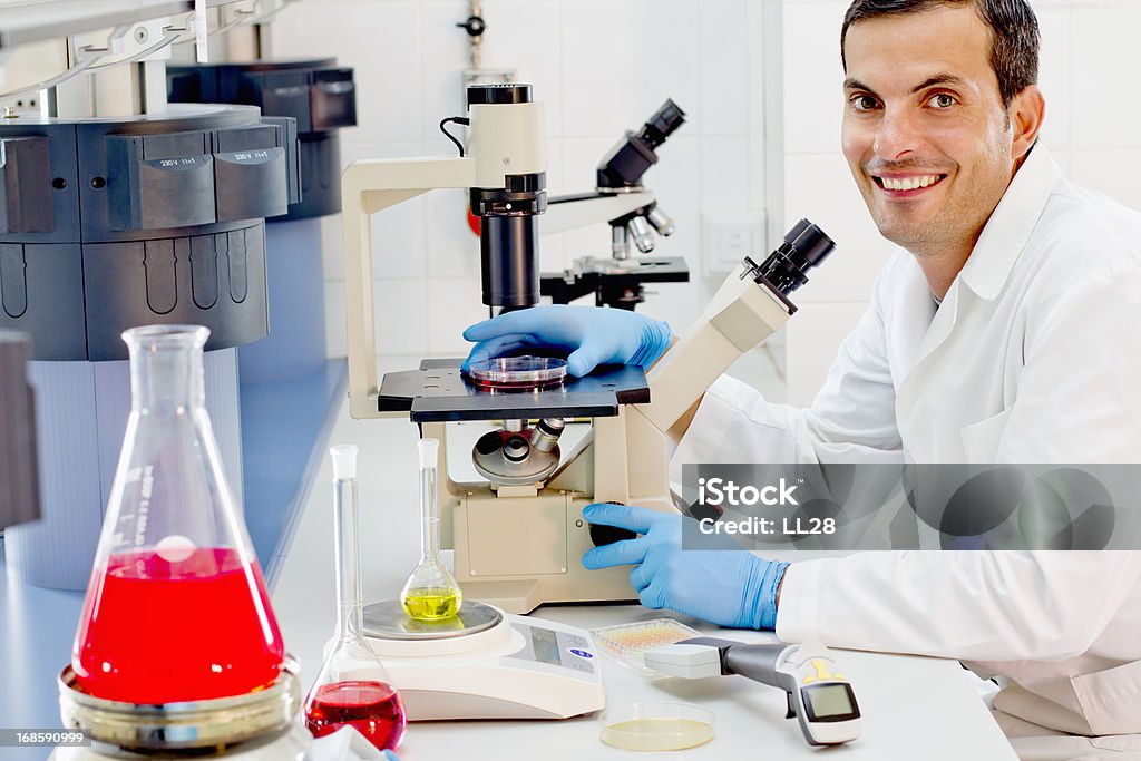 Chimico alla sua postazione di lavoro in un laboratorio farmaceutico - Foto stock royalty-free di 30-34 anni