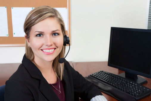 Smiling female executive talking on phone in office