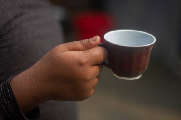 istock a human hand holding a cup of tea and the blurred background 1685929338