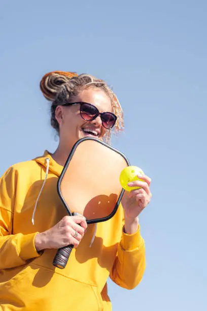 Photo of portrait woman player pickleball game, pickleball yellow ball with paddle, outdoor sport leisure activity.