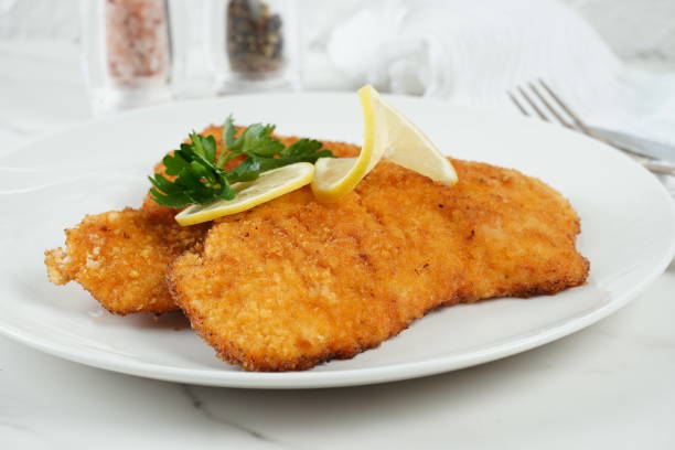 istock Two turkey breaded schnitzel with lemon on plate 1685958940