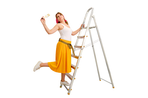 Russian woman painter in a red bandana stands on a stepladder, isolated on a white background