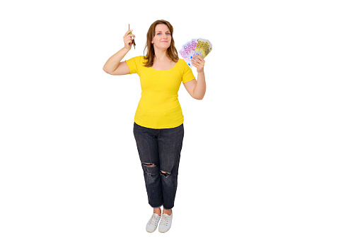 Smiling woman buyer of new modern house with money in hand on empty room, isolated on a white background