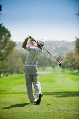 A golfer at the end of his golf swing.