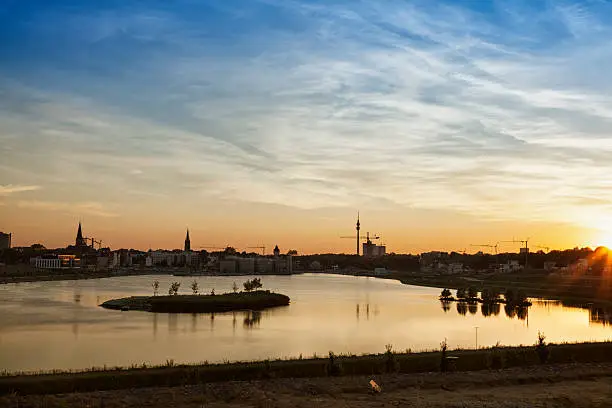 Lake Phoenix, built at former industrial area, and Dortmund cityscape at sunset