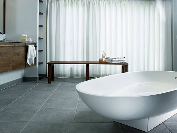 Freestanding bathtub Bathtub on tiled floor with curtains and bench wet wood texture stock pictures, royalty-free photos & images