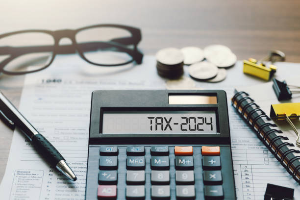 fotografii de stoc, fotografii și imagini scutite de redevențe cu word tax 2024 pe calculator. conceptul de afaceri și fiscal. calculator, monede, carte, formular fiscal și stilou pe masă. planificarea deducerilor fiscale. cercetare financiară, impozite guvernamentale și declarații fiscale de calcul - formular de impozit