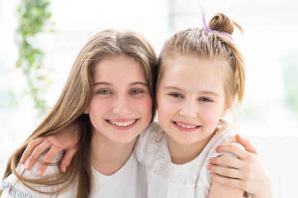 istock Cute smiling sisters embracing 1686044170