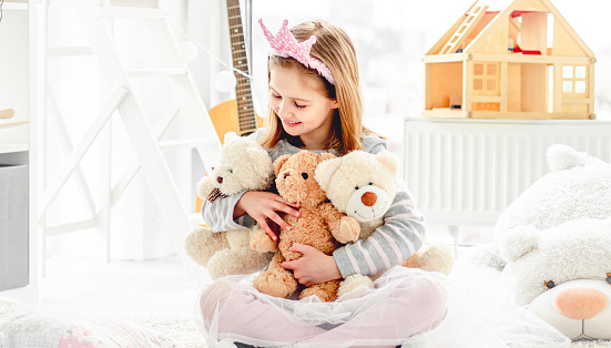 A family with two children holding teddy bears, prizes won in an amusement arcade. The boy is hugging the giant stuffed toy.