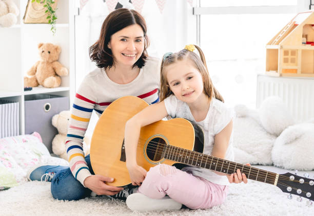 istock Mother with daughter playing guitar 1686051452