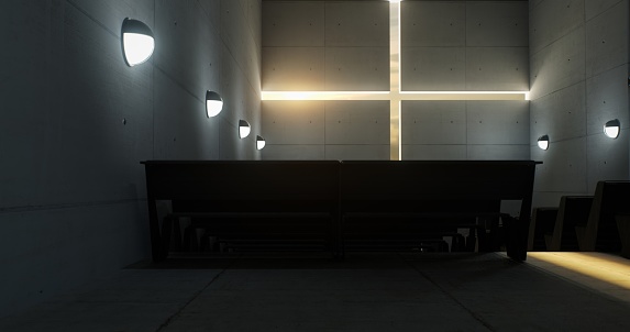 The sun casts its radiant beams through the cross-shaped opening in the wall of a contemporary church, bathing the interior in a warm, ethereal glow.
