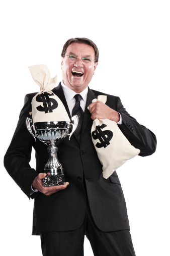 cheerful businessman holding trophy and money bags