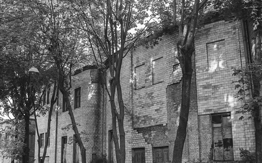 The front of an abandoned building with green windows and brown brick in Cairo, Illinois