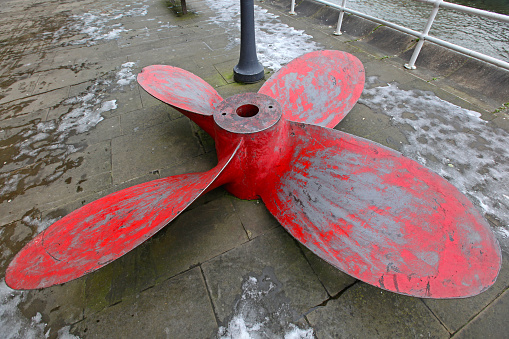 Large Red Propeller With Four Blades at Street Pavement Winter Day