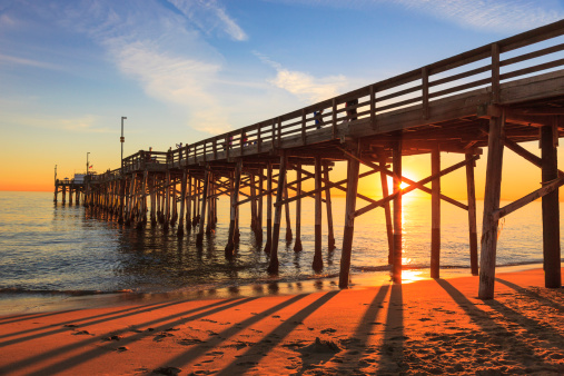 Incoming tide reflects the sunset at Balboa Pier in Newport Beach, CA