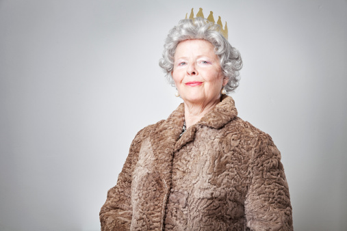 senior woman wearing a crown and a fur coat