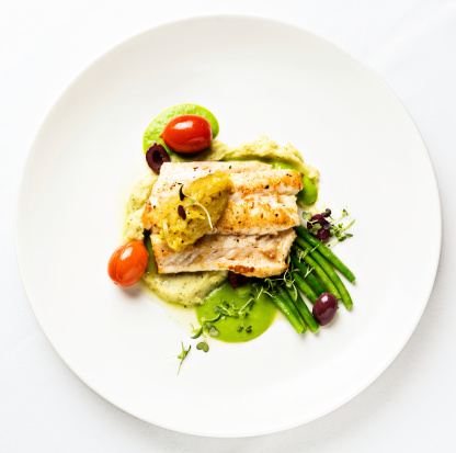 Grilled fish with lentil puree and vegetables seen from above